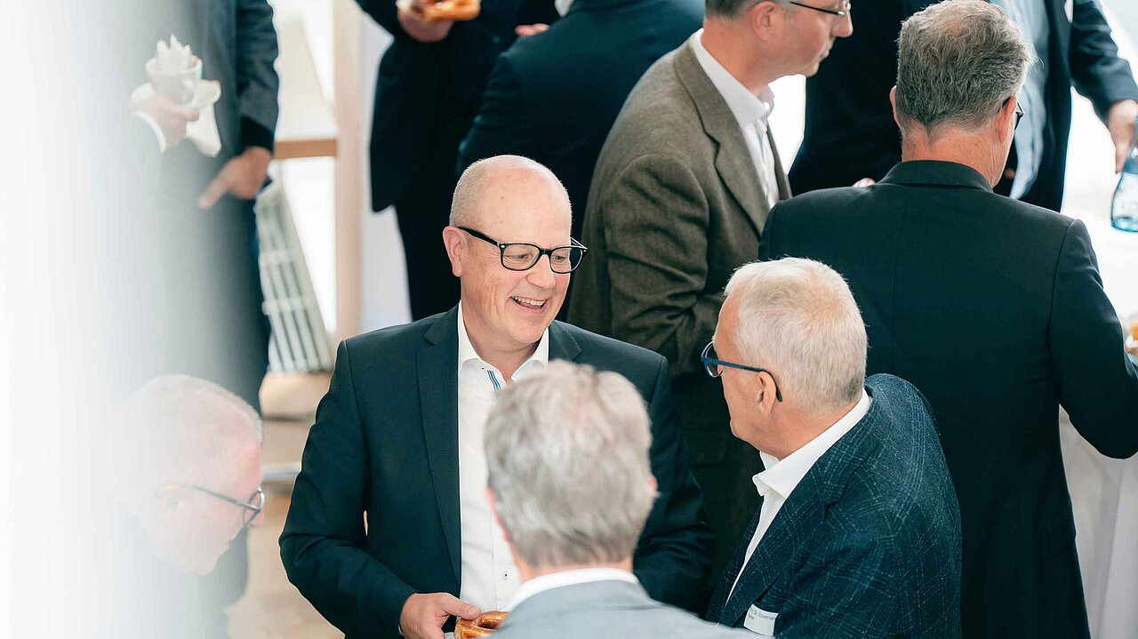 Teilnehmende einer Fachveranstaltung im Gespräch während einer Netzwerkpause