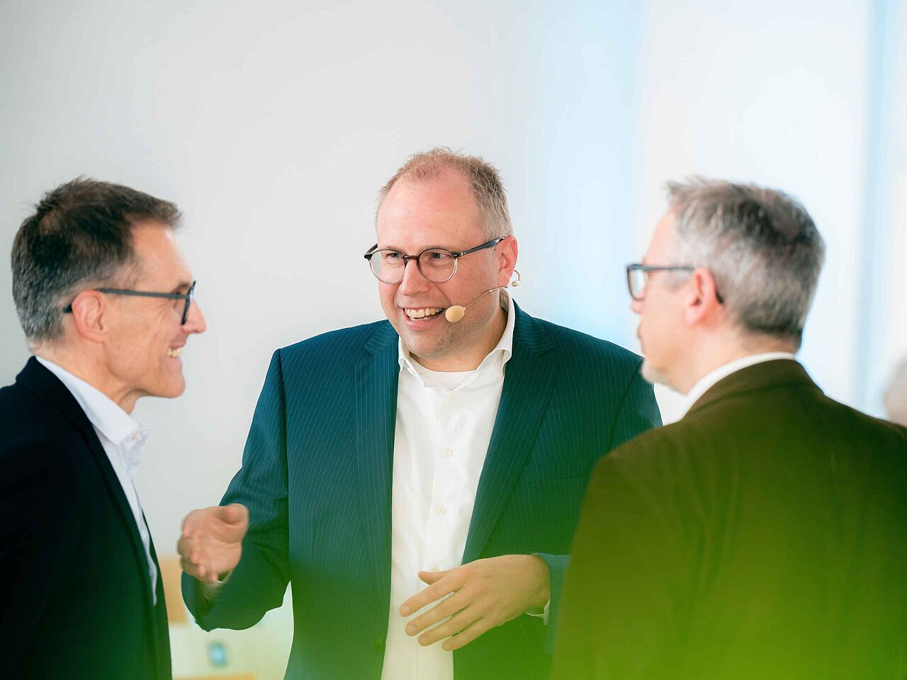 Mehrere Teilnehmende einer Veranstaltung diskutieren in einer Gesprächsrunde während einer Pause